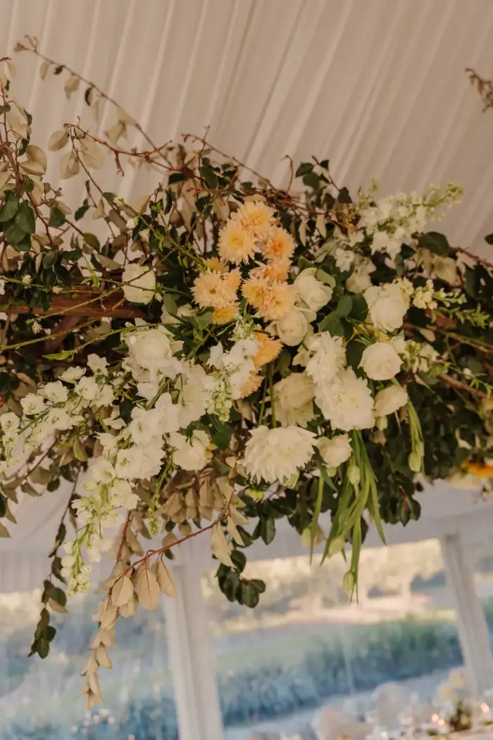 Suspended white and green floral installation beside the marquee windows