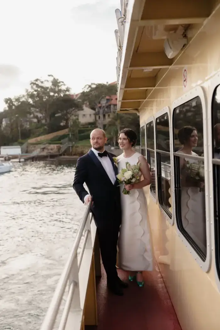 Newlyweds standing on the deck of a Sydney ferry