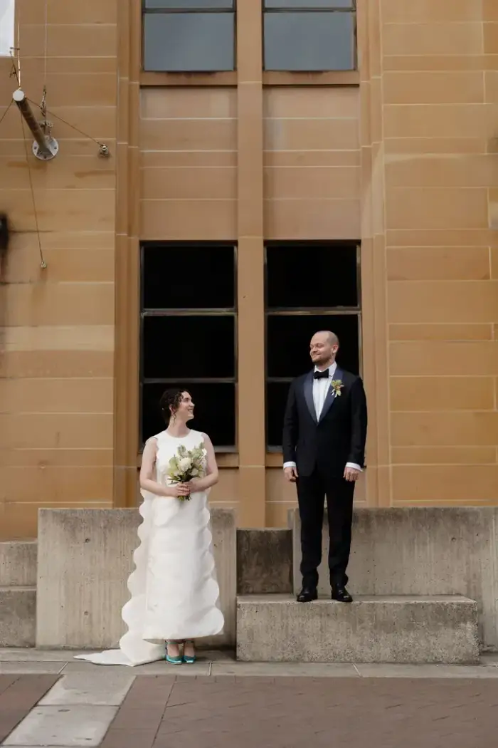 Bride and groom standing in separate sandstone doorways, looking at each other